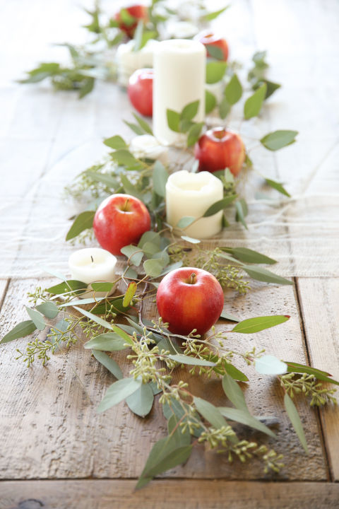 simple-apples-become-sophisticated-when-cushioned-by-seeded-eucalyptus-and-pillar-candles-as-in-this-easy-centerpiece